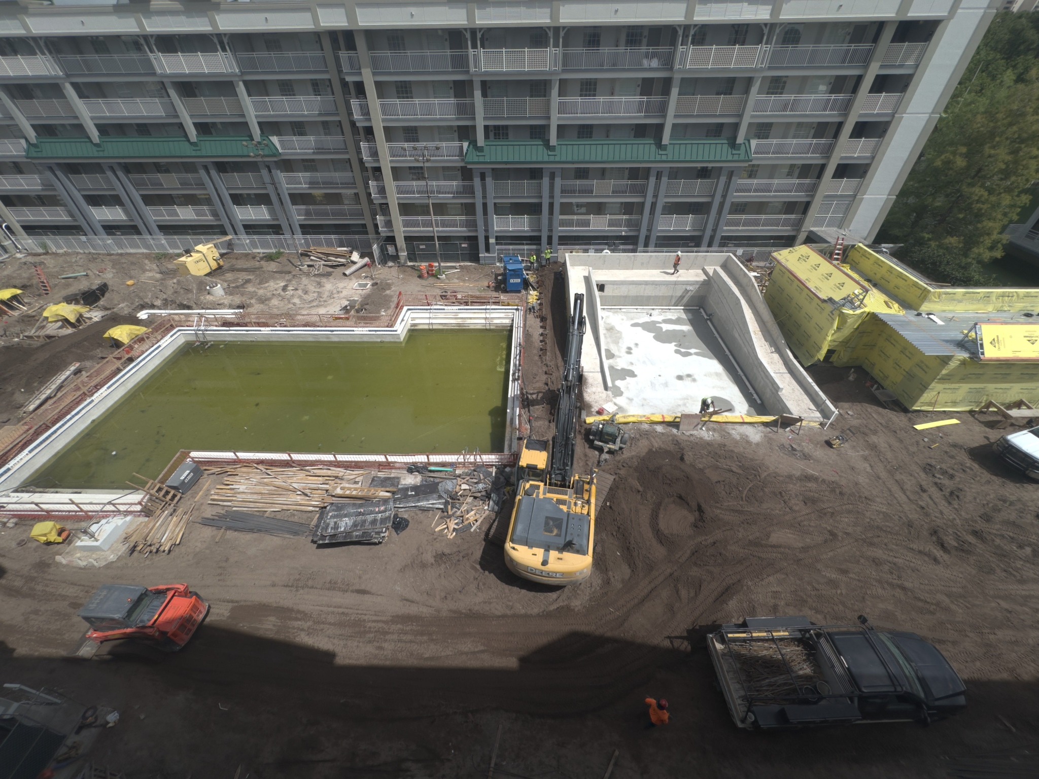 Overview of structural excavation and support work beside a building